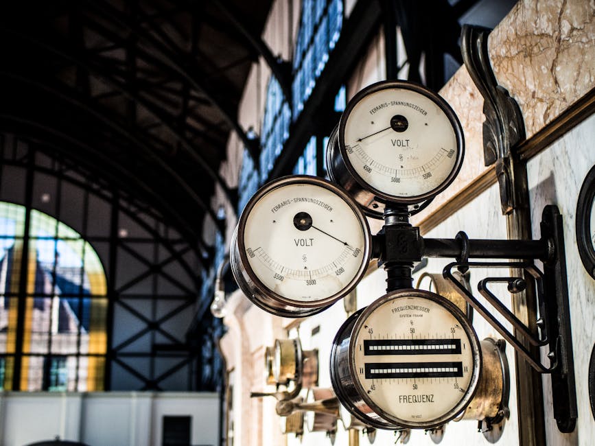 Intricate vintage volt and frequency gauges in an industrial setting with blurred background.