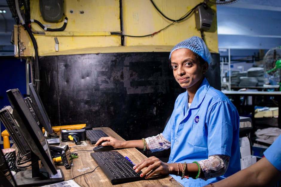 Female factory worker operating a computer in an industrial setting, highlighting modern textile manufacturing.